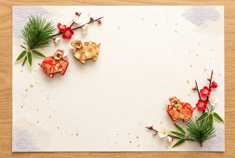 Japanese New Year card background with origami sheep, pine, bamboo and plum on washi paper