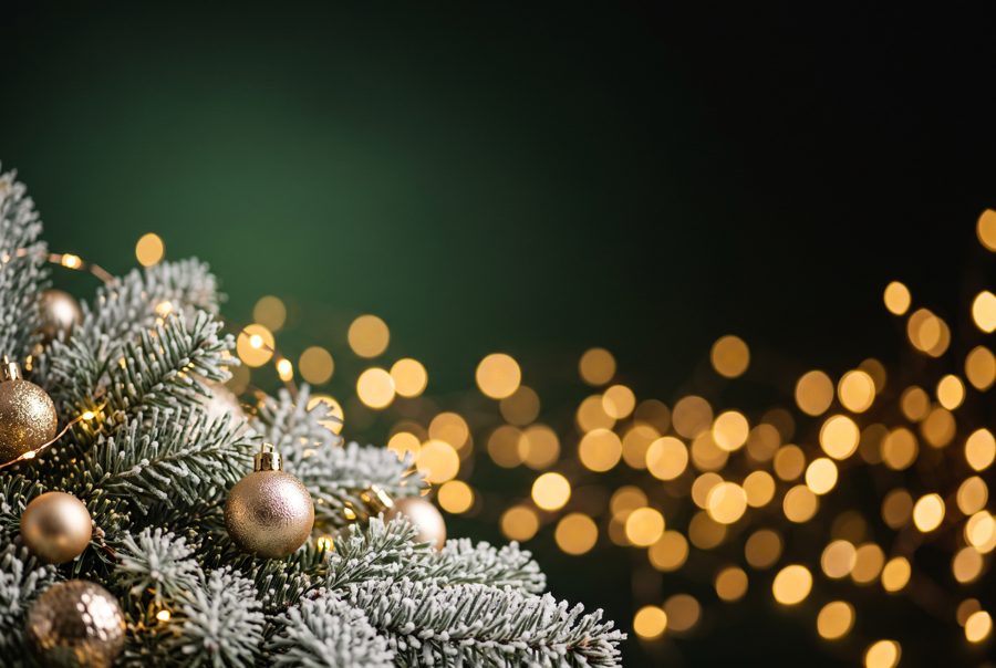 Christmas background with golden bokeh lights, fir branches and gold baubles
