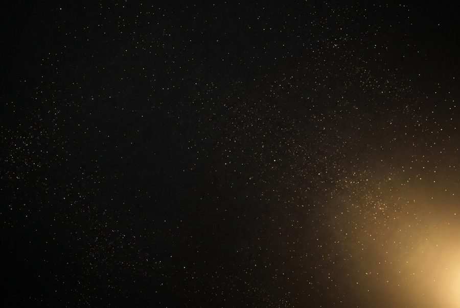 Luxury black background with gold dust particles and soft glow