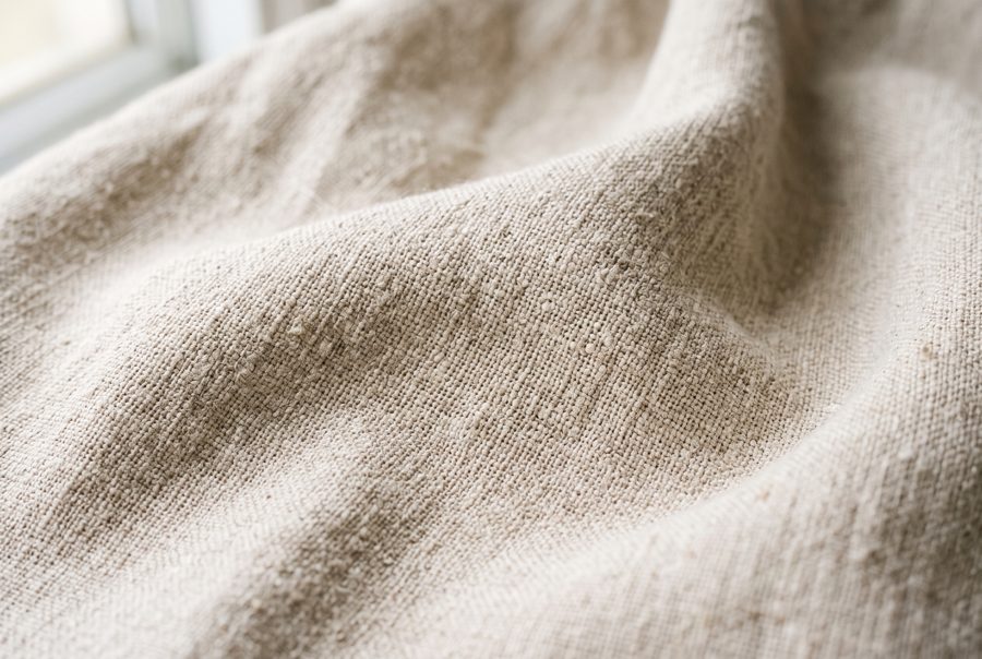 Natural oatmeal linen fabric texture with soft folds, background