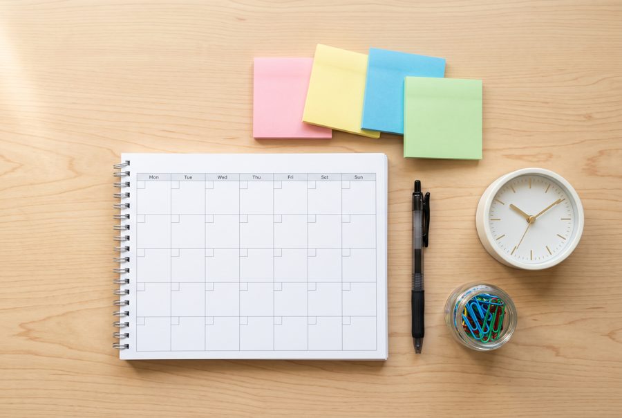 Blank planner, sticky notes, pen and clock on white desk, planning concept