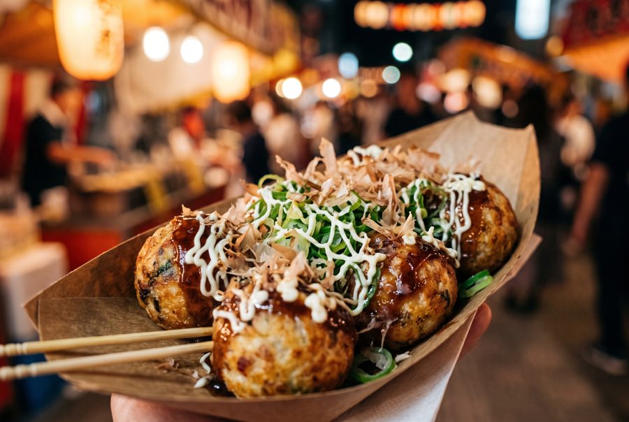 Takoyaki with bonito flakes and sauce in paper boat, Japanese street food