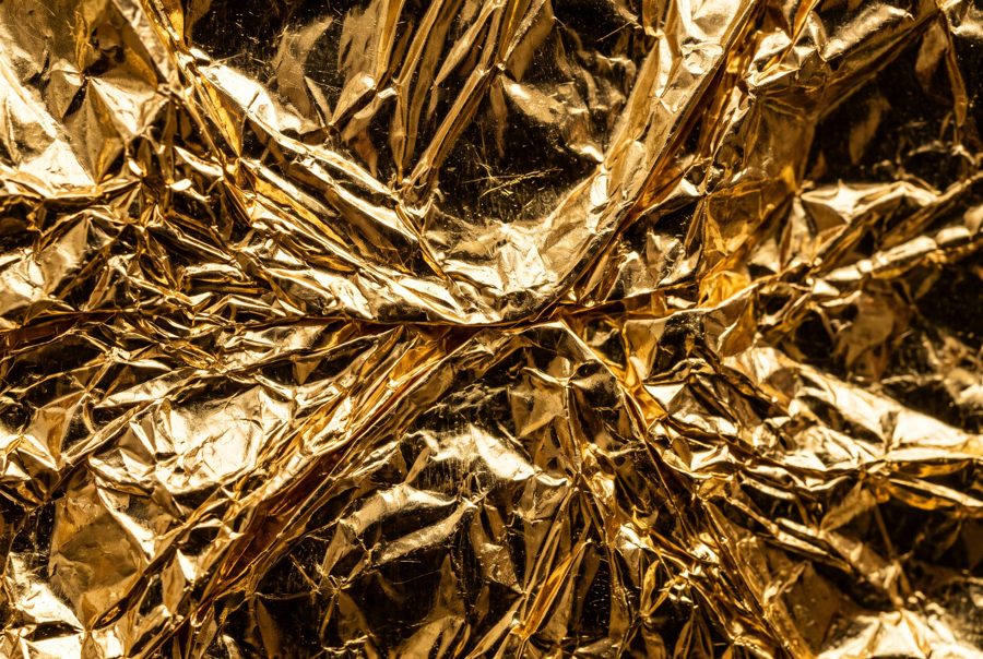 Crumpled gold foil texture with metallic reflections, luxury background