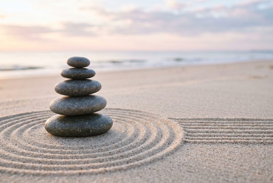 Stacked zen stones on raked sand, minimal meditation background